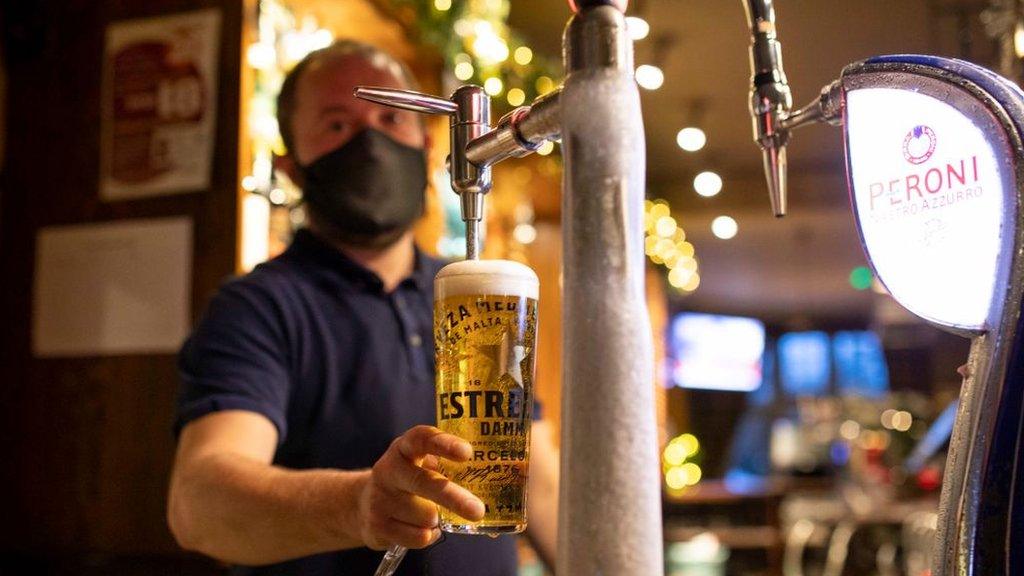 Man pulls a pint in a pub - stock image