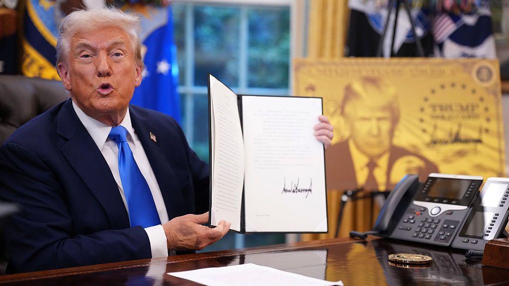  President Donald Trump holds up an executive order establishing the "Trump Gold Card" in the Oval Office at the White House on September 19, 2025 in Washington, DC. Trump signed a series of executive orders establishing the “Trump Gold Card” and introducing a $100,000 fee for H-1B visas. The "Trump Gold Card" is a visa program that allows foreign nationals permanent residency and a pathway to U.S. citizenship for a $1 million investment in the United States
