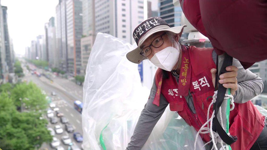 Kim Yong-Hee looks at the camera from the top of the 20m high traffic tower