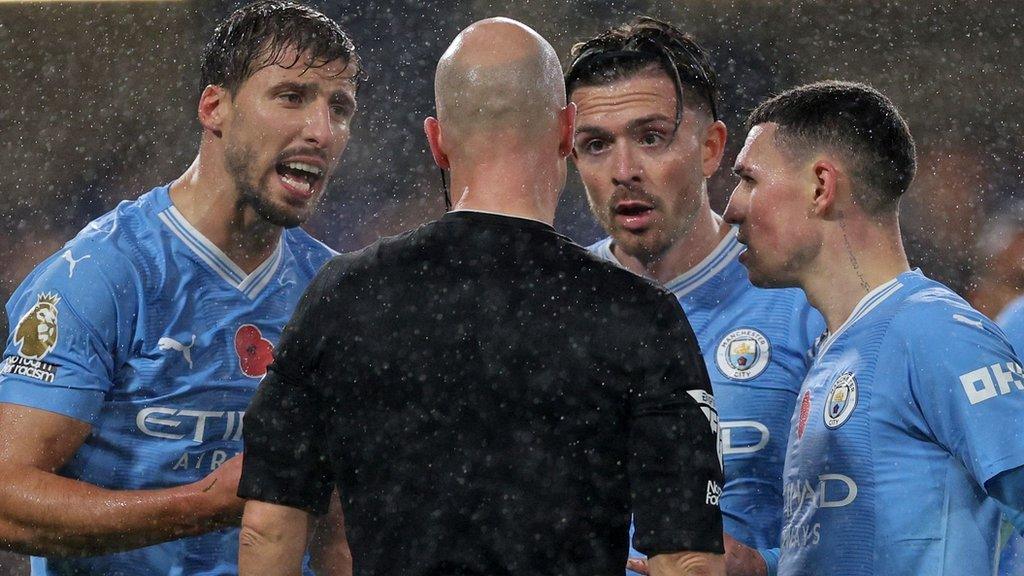 Man City players surround the referee