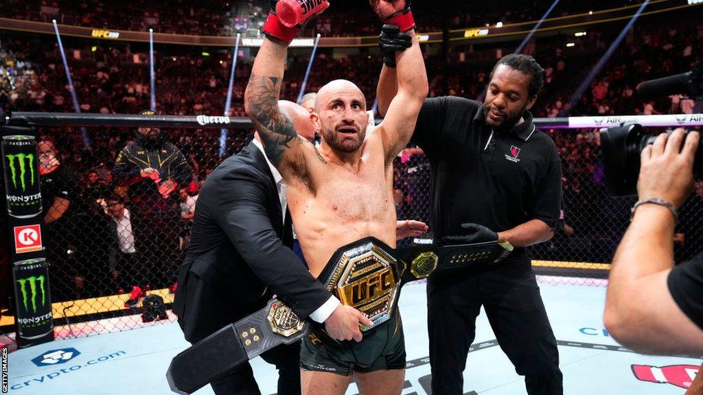 Alexander Volkanovsi is presented with the UFC featherweight title after beating Yair Rodriguez