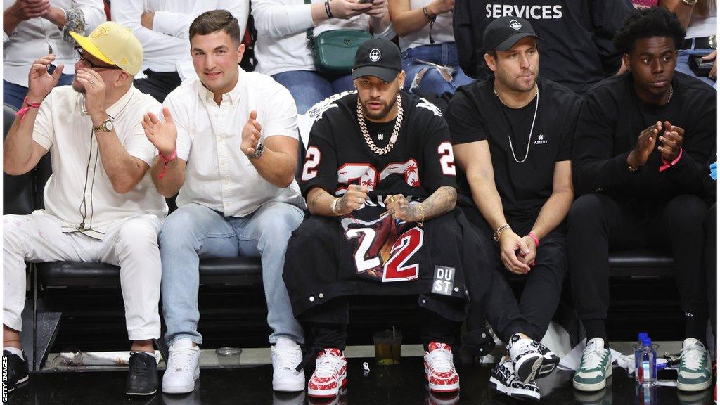 Neymar watching an NBA game courtside