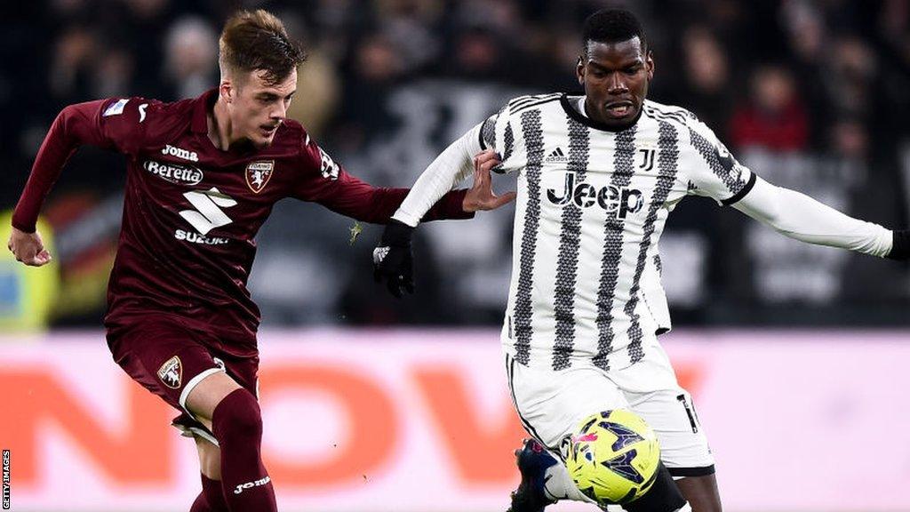 Juventus midfielder Paul Pogba competes for the ball with Torino's Ivan Ilic