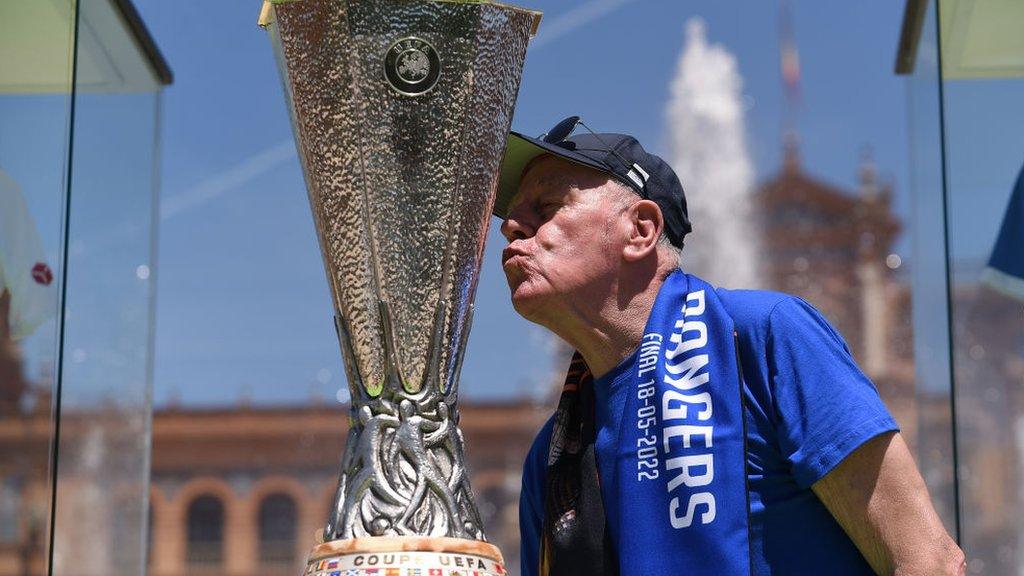 A Rangers fan kisses a replica of the Europa League trophy