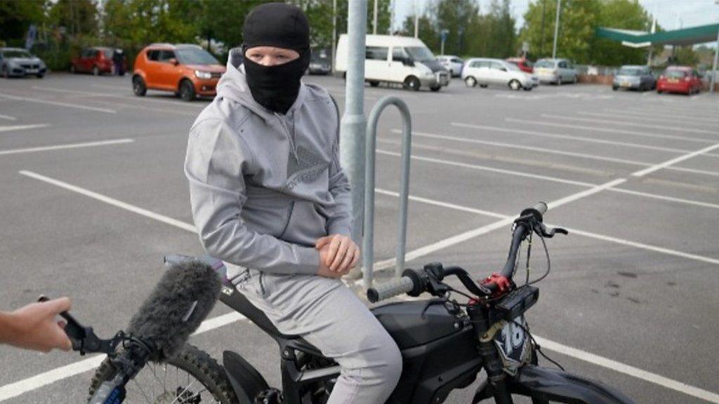 Man in balaclava on e-motorbike