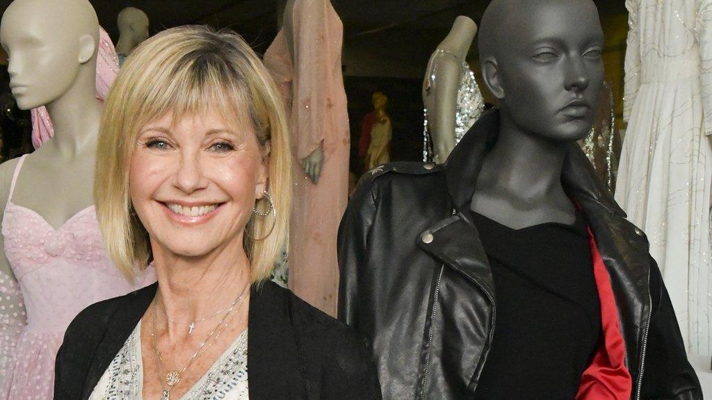 Olivia Newton-John next to her jacket before the auction