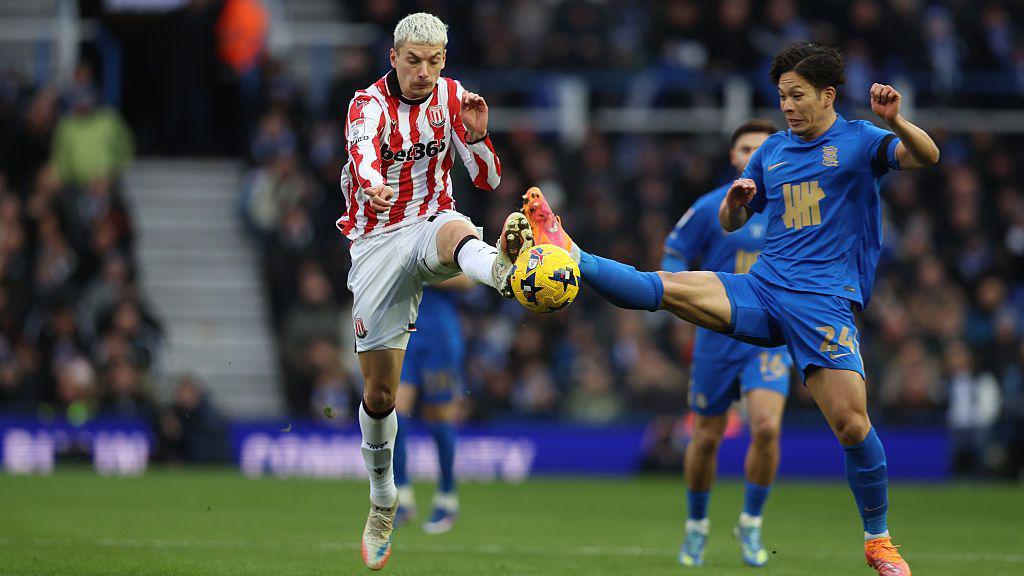 Stoke City's Tomas Rigo and Birmingham City's Tomoki Iwata compete for the ball.