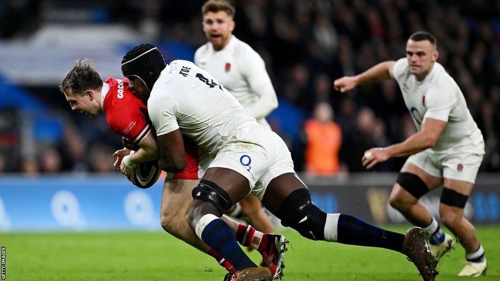 Wales fly-half Ioan Lloyd is tackled by England lock Maro Itoje