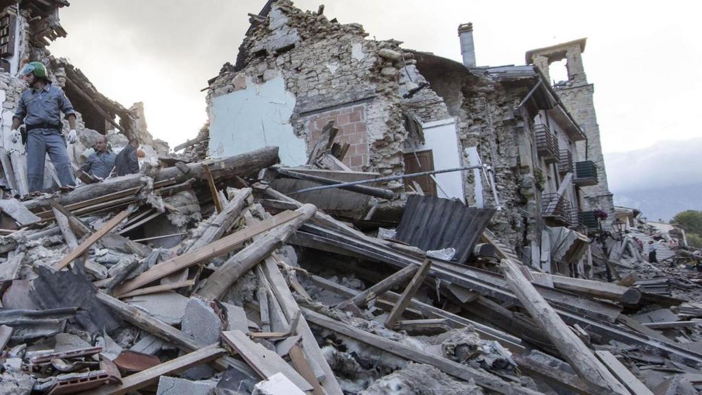 Rescuer searching a collapsed building in Amatrice,