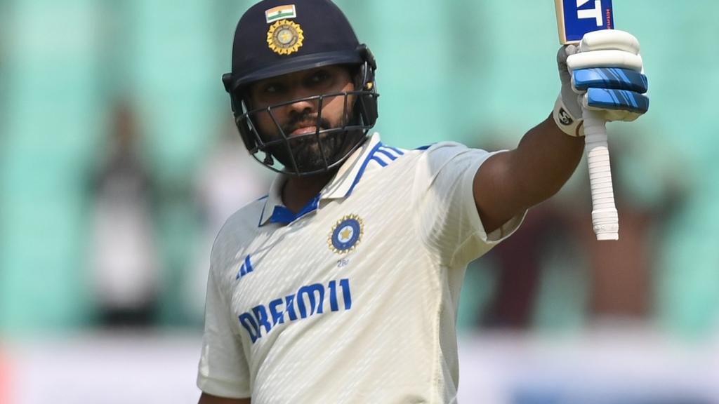 India captain Rohit Sharma raises his bat after hitting a century