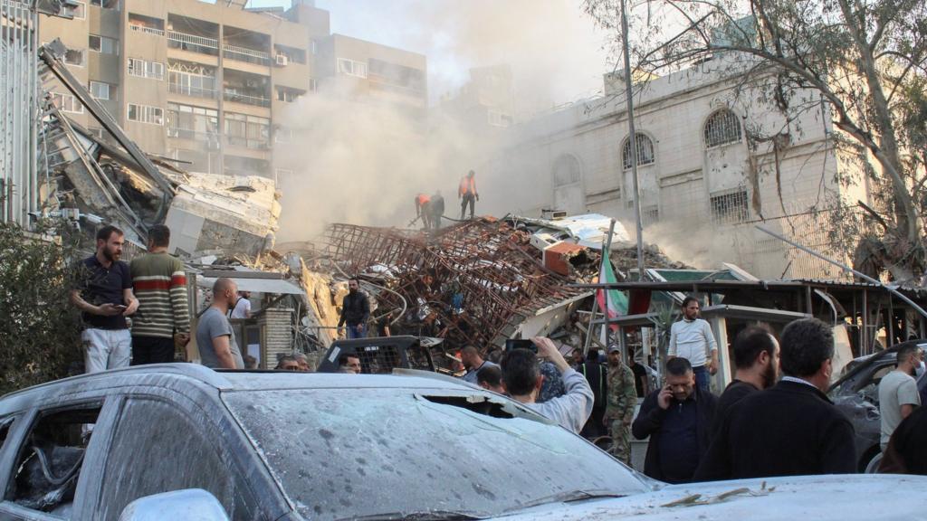 People gather near wreckage at the site of the strike