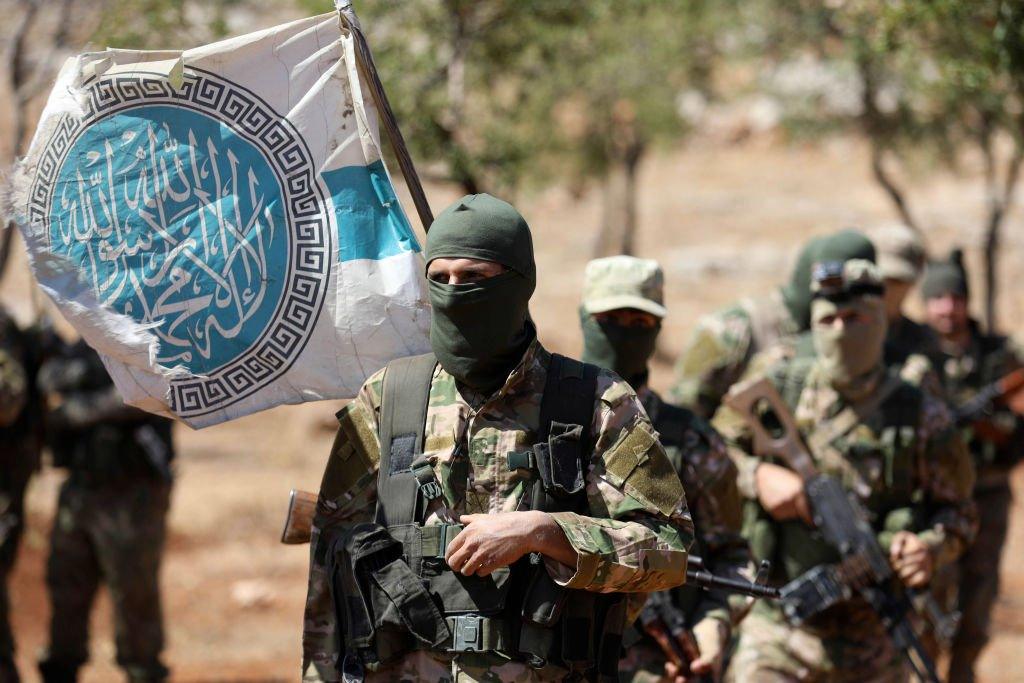 Masked HTS fighters carrying flag