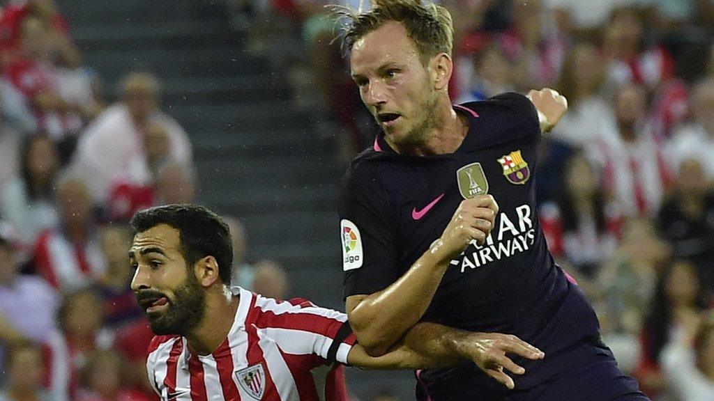 Barcelona"s Ivan Rakitic, right, heads the ball to goal beside Athletic Bilbao's Mikel Balenziaga