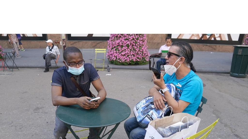 People sit with shopping bags outside of Macy"s Herald Square store on the first day of the phase two re-opening of businesses following the outbreak of the coronavirus disease (COVID-19), in the Manhattan borough of New York City, New York, U.S., June 22,