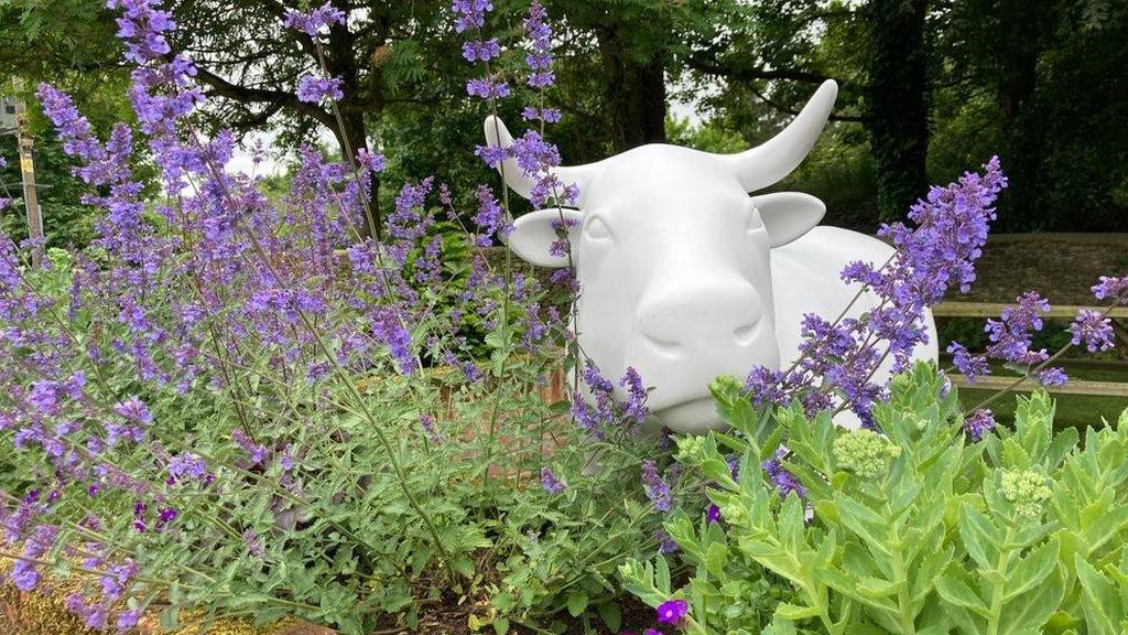 A sculpture of an ox in a garden