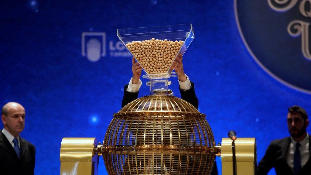 Lottery balls are dropped into a rotating drum during the draw.