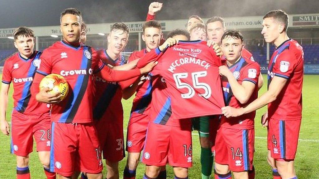 Rochdale players hold a shirt in support of ill five-year-old Joshua McCormack