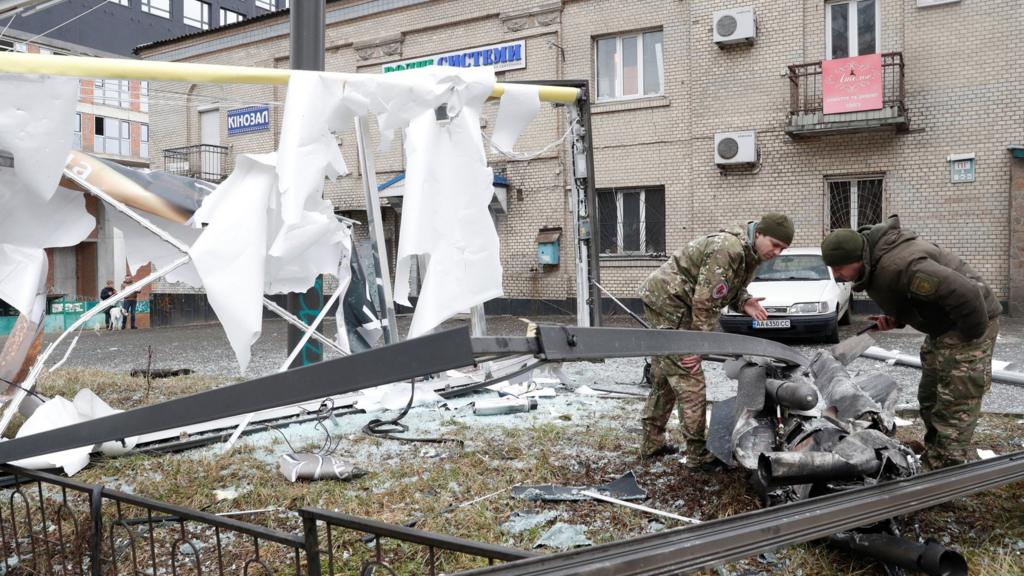 Police officers inspect the remains of a missile that fell in the street, after Russian President Vladimir Putin authorized a military operation in eastern Ukraine, in Kyiv, Ukraine February 24, 2022