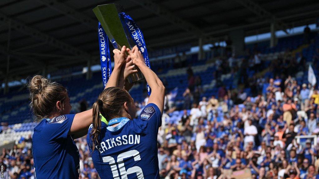 Millie Bright and Magda Eriksson hold the trophy aloft