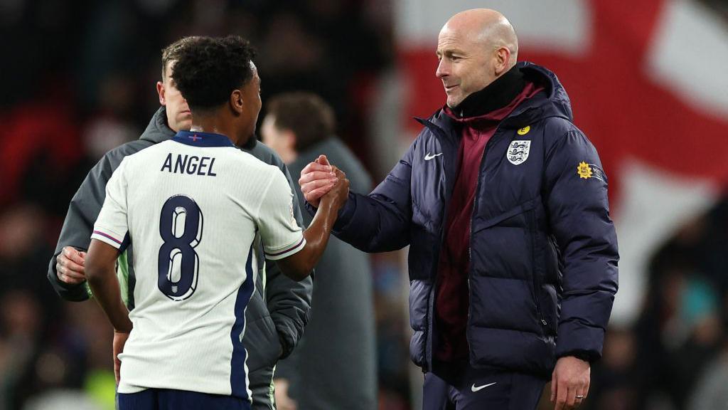 Lee Carsley and Angel Gomes shake hands after an England appearance