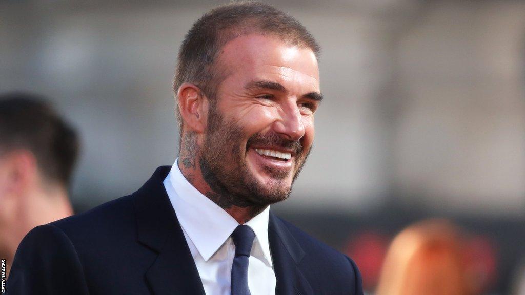 David Beckham smiling wearing a suit