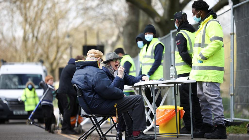 People swab themselves for coronavirus at a testing site on Clapham Common in London