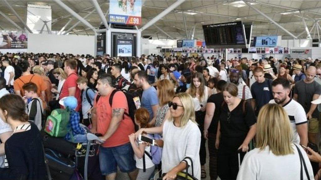 Passengers wait following flight disruption at London Stansted Airport