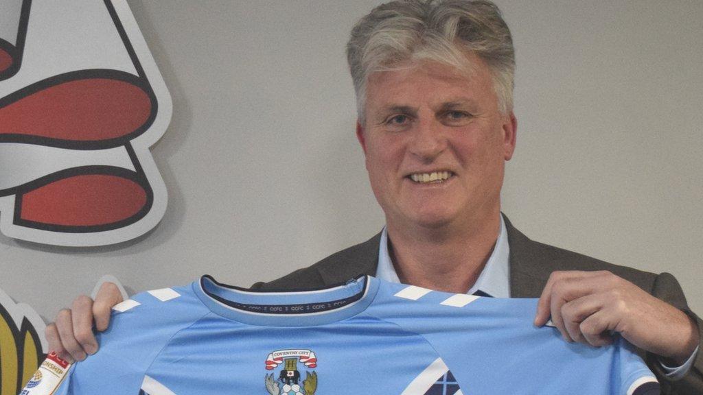 Doug King holding a Coventry shirt