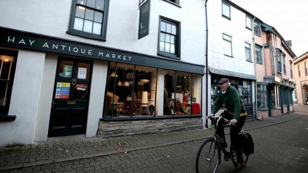 Cyclist in deserted street in Hay-on-Wye, Powys