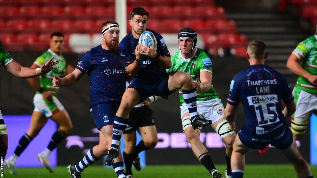 AJ MacGinty (centre) jumps and collects the ball during Bristol's win against Leicester