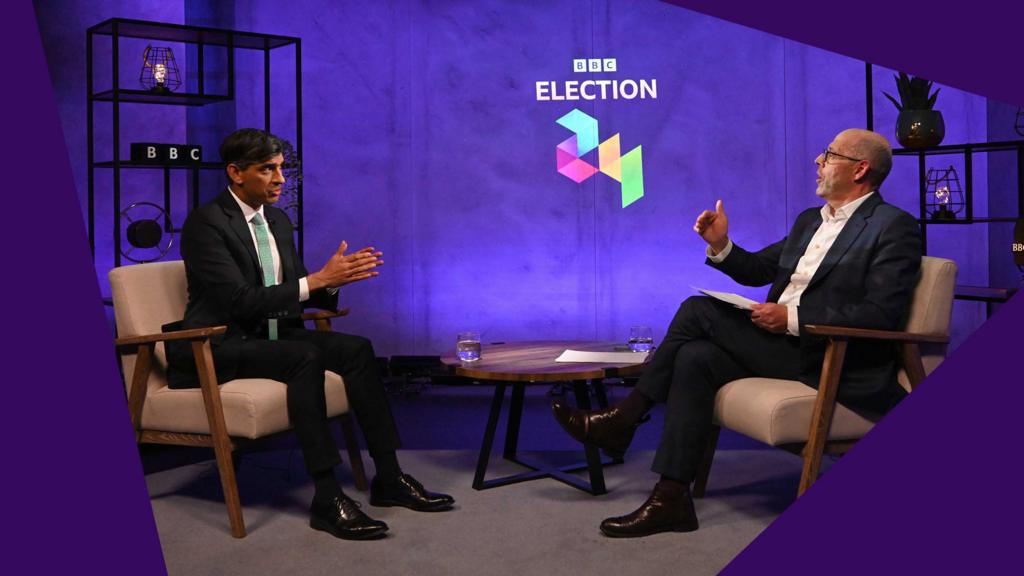 Rishi Sunak and Nick Robinson sit facing each other with the BBC's election branding between them