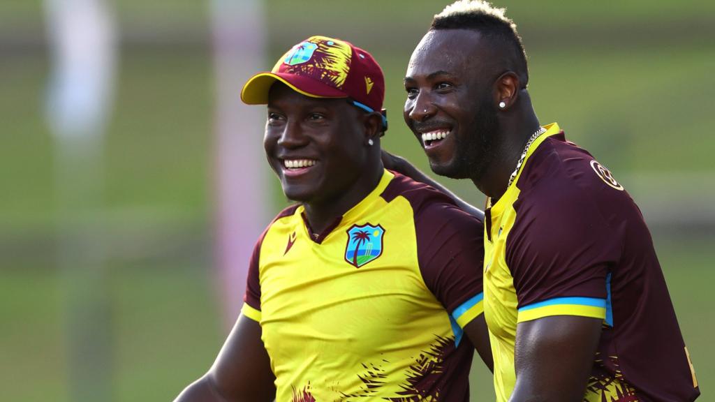 West Indies players Rovman Powell (left) and Andre Russell (right) celebrate a wicket