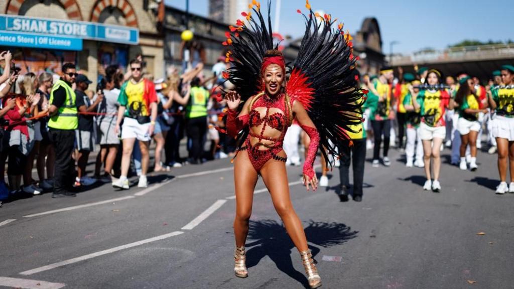 A dancer dancing through the street as onlookers watch on