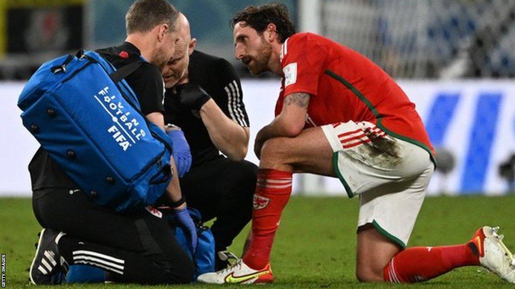 Joe Allen is treated by Wales' medical staff before being withdrawn in the 81st minute of the defeat to England