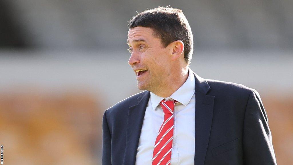 Swindon Town chief executive Rob Angus chatting before a League Two match.