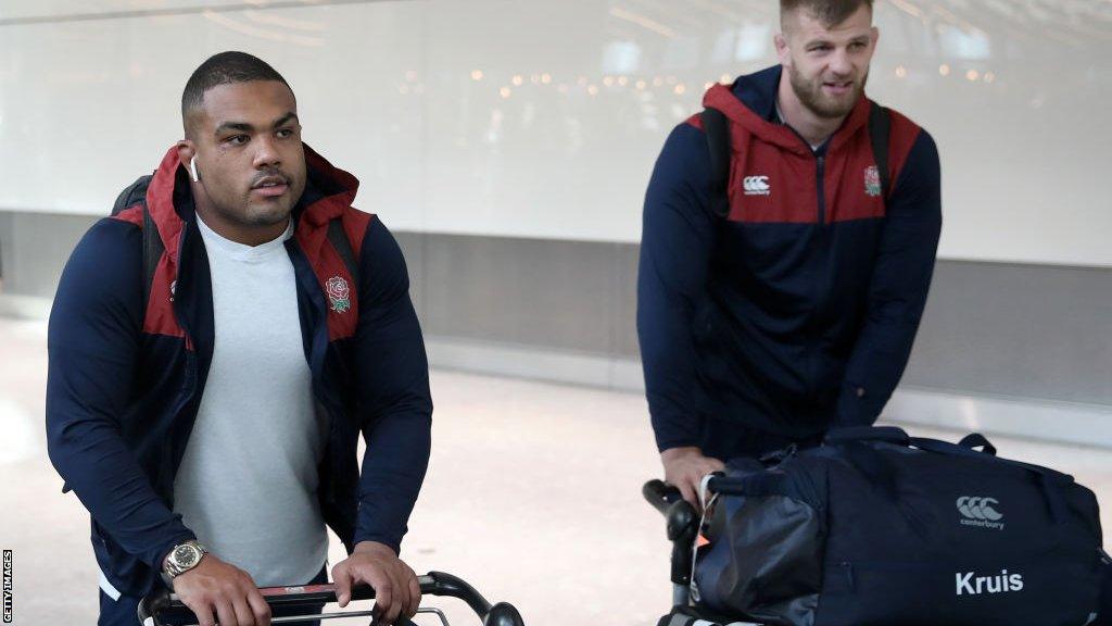 Kyle Sinckler and George Kruis push baggage trollies through Heathrow airport