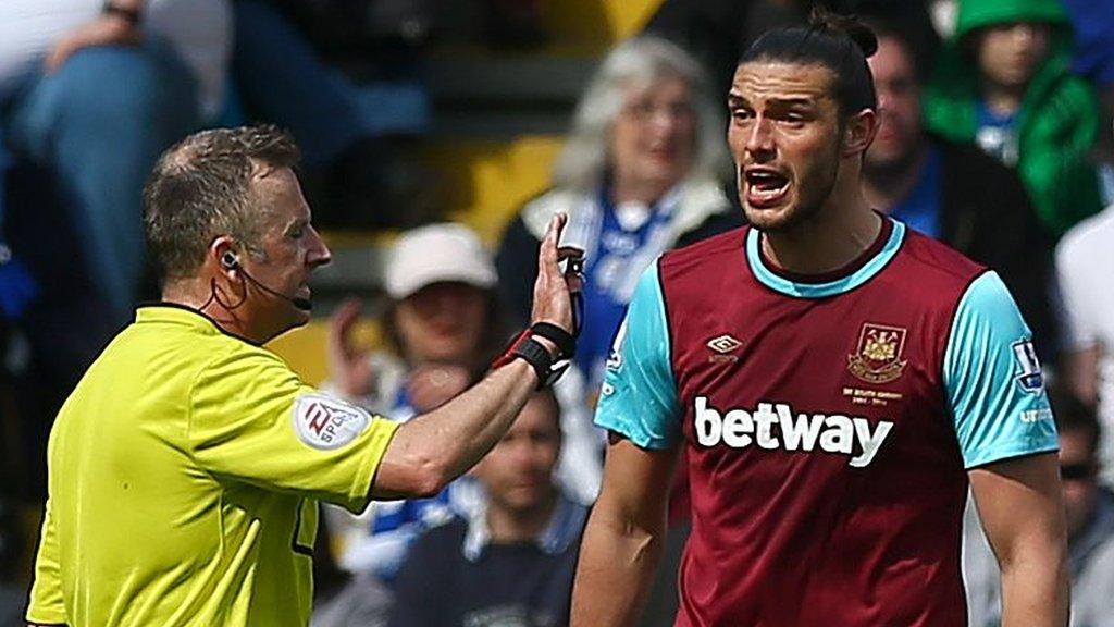 Referee Jonathan Moss and West Ham striker Andy Carroll