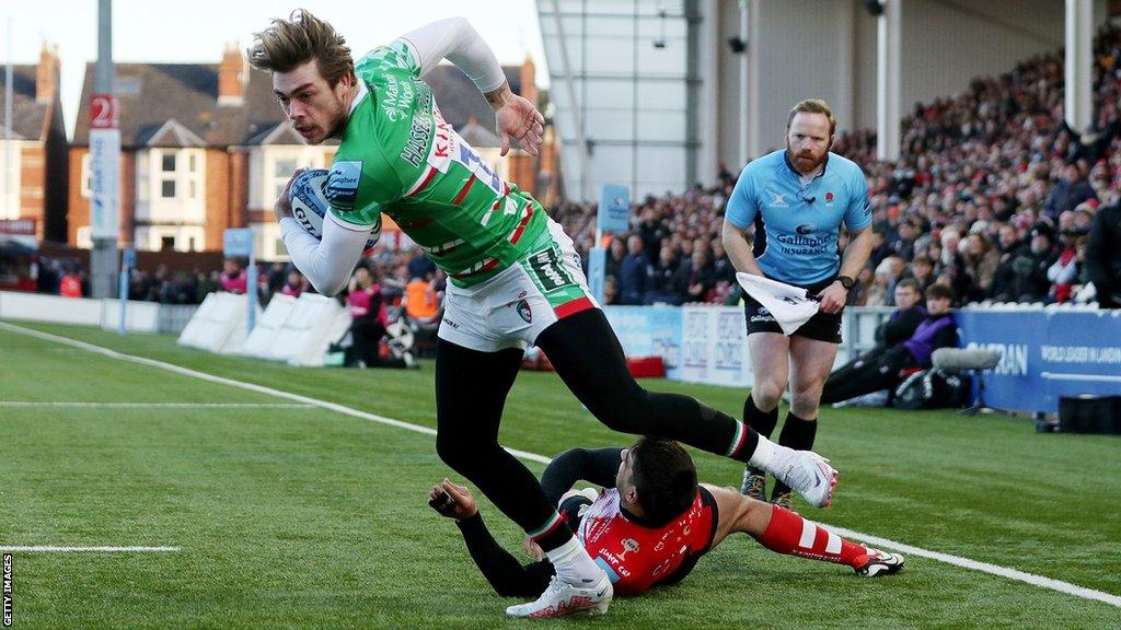 Ollie Hassell-Collins holds the ball under a tackle from Santiago Carreras before scoring