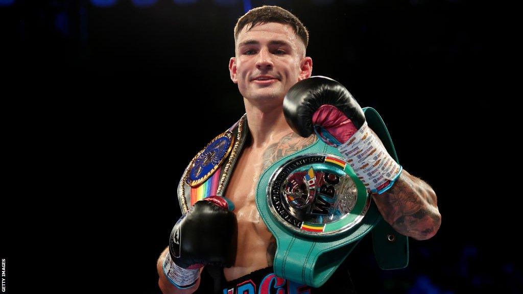 Sam Noakes celebrates with his belts around his shoulder