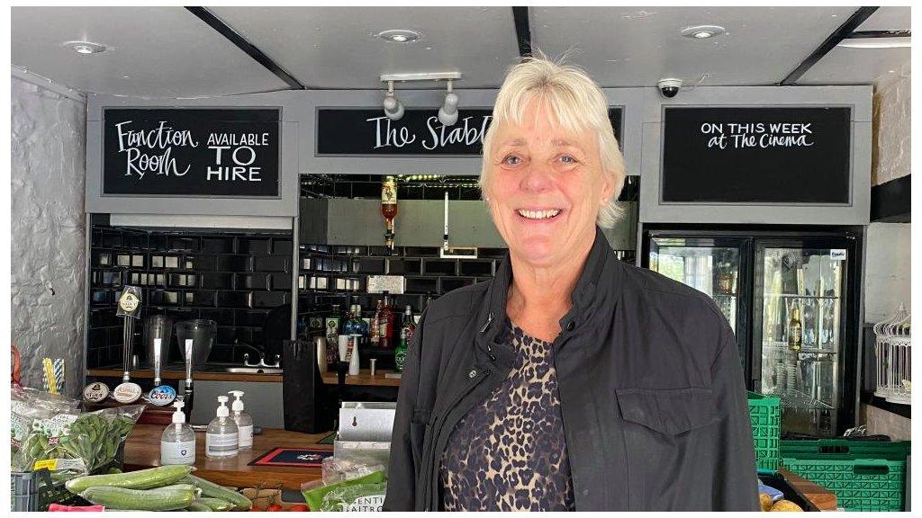 Smiling woman in front of shop counter