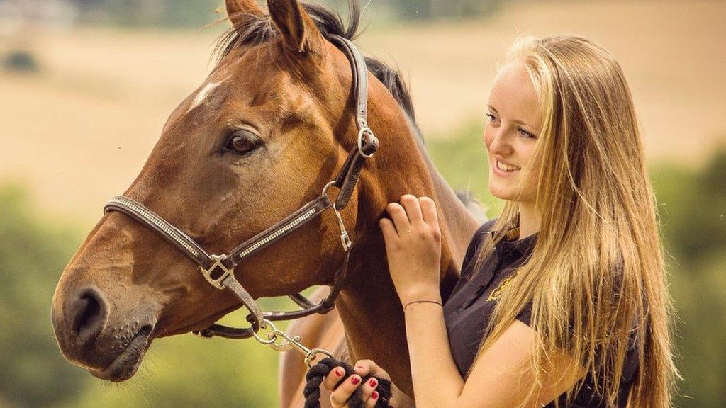 Gracie Spinks in a field with a horse