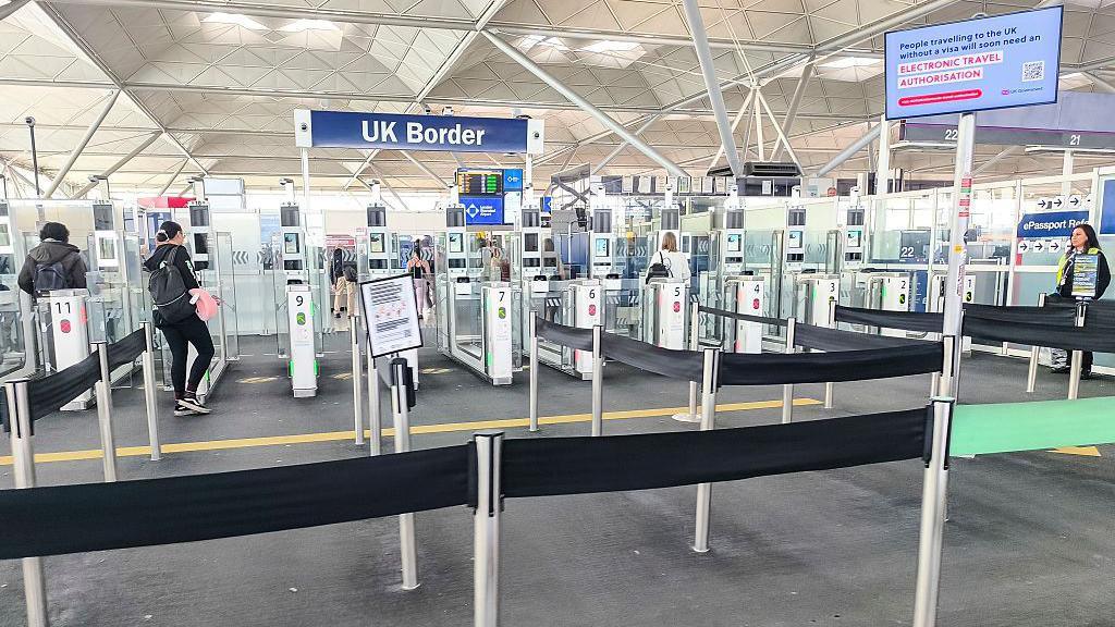 Biometric passport control entry gates at London Stansted Airport.