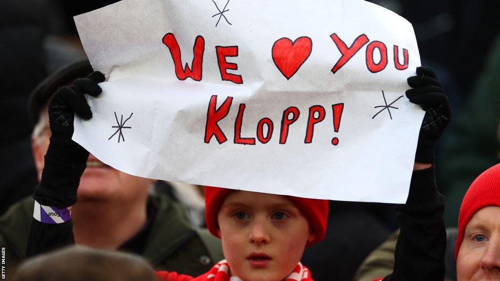 A young fan brandishes a banner during Liverpool's FA Cup victory over Norwich