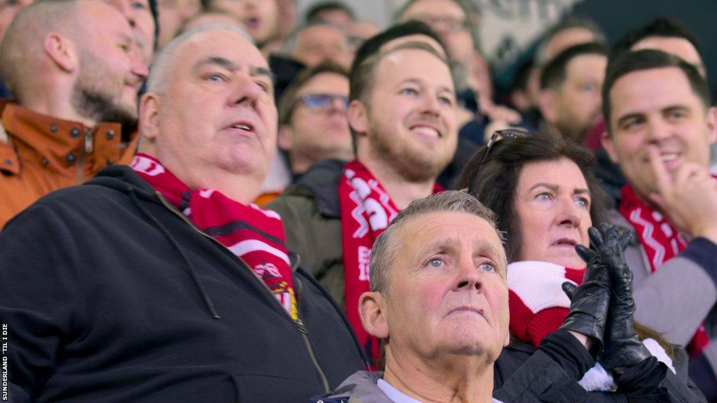 Ian Wake and Michelle Barraclough in the stands at football stadium.