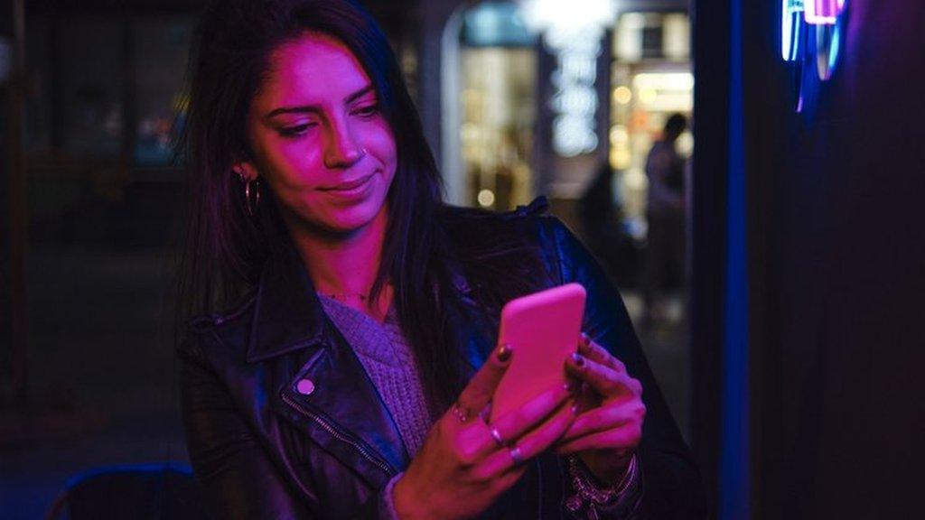 Woman checks phone at a club