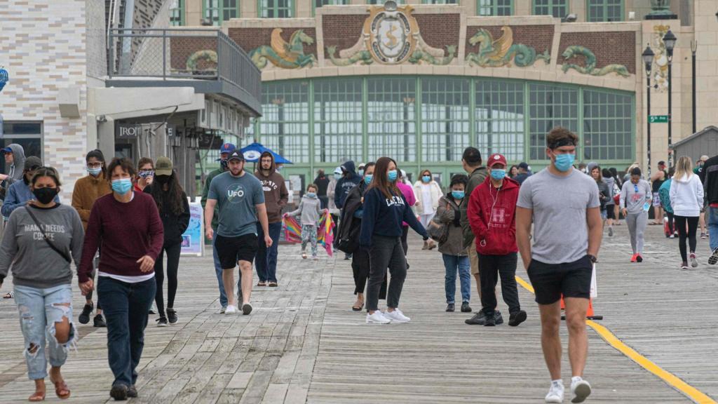 People walk by the boardwalk in Asbury Park, New Jersey on May 24, 2020, as tourists get started on the Memorial Day weekend