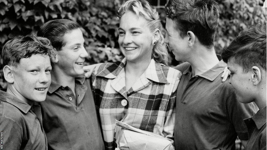 A group of ball boys meet American Darlene Hard, who finished as runner-up to Althea Gibson, at the 1957 Championships