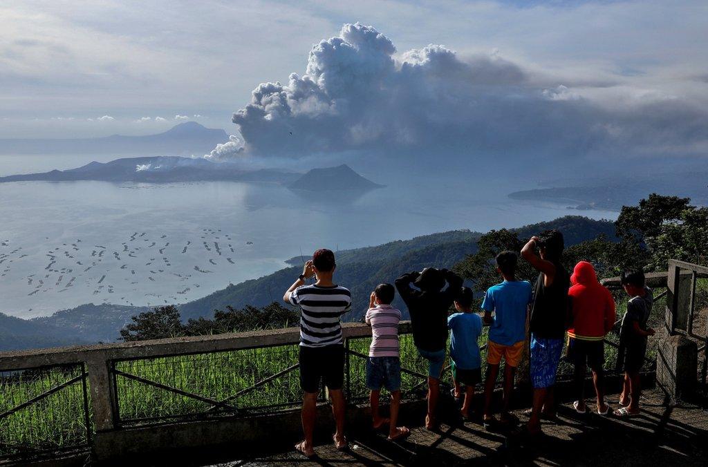 Residents look at the erupting Taal Volcano in Tagaytay City, Philippines, January 13