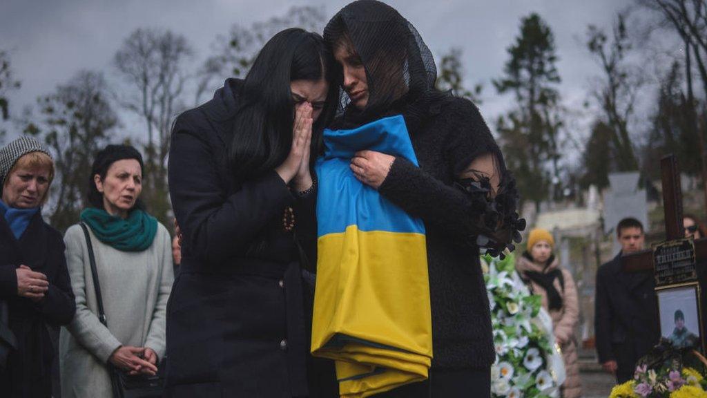 Women crying at a cemetery in Lviv, March 2024