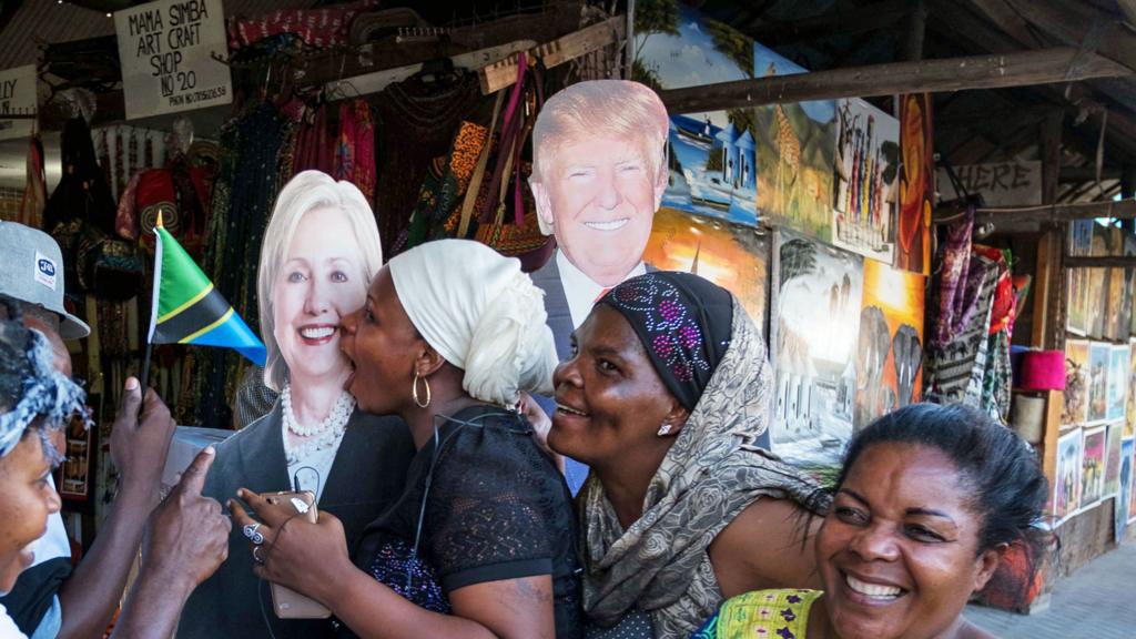 People pose with cut outs of US politicians Hillary Clinton and Donald Trump at a public relations campaign put on by the US Embassy in Dar es Salaam, Tanzania on 7 November 2016